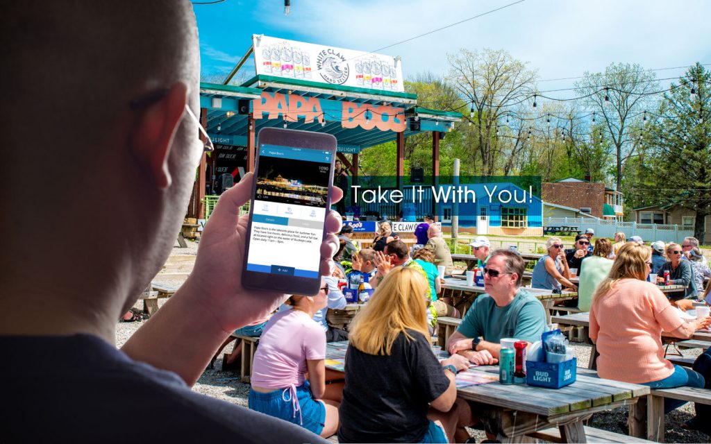 man with his phone in front of a crowd eating and listening to music