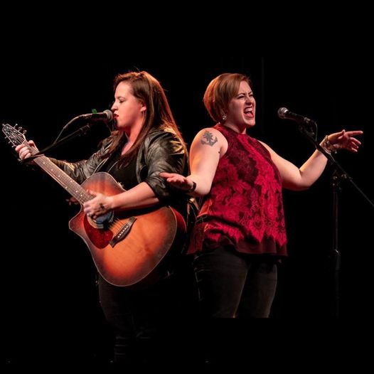 Two women singing on stage.
