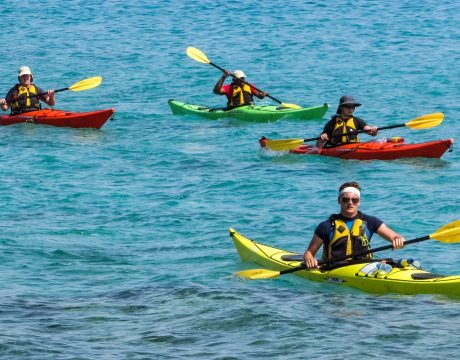 Four kayaks paddling in the water.