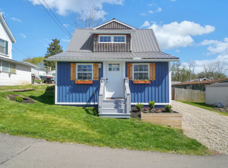 A quaint, blue suburban home with flowerbox windows.