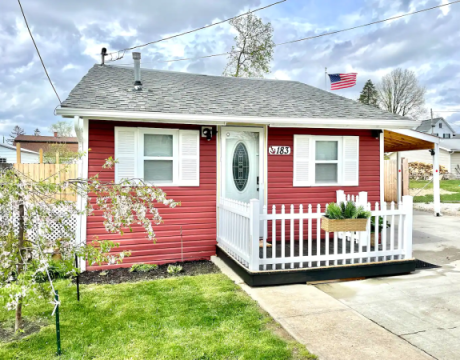 Photo of the outside of a little red house