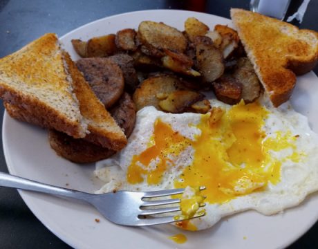 Photo of a plate full of eggs, toast, and roasted potatoes.