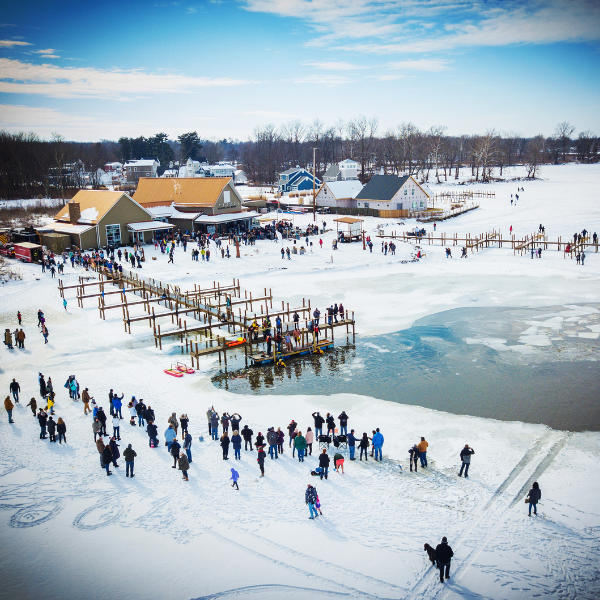 A crowd stands on a frozen lake.