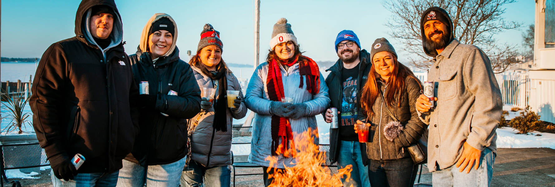 Photo of a group of people enjoying drinks by a firepit at the 2024 Winterfest in Buckeye Lake.