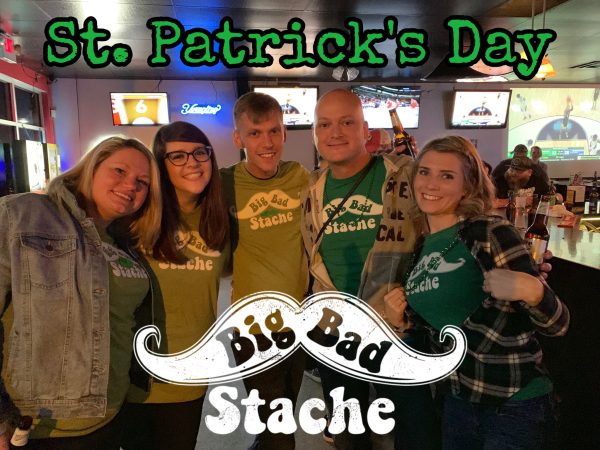 Group of people standing together and wearing green for St. Patrick's Day, promoting the band Big Bad Stache.