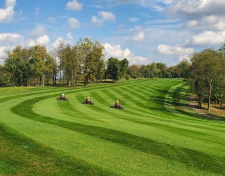 Three people on lawn mowers mow the grass of Whitetail Ridge Golf Course near Buckeye Lake.