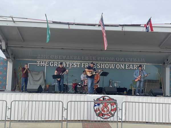 The band, Water on the Fire, playing on a stage during the day time.