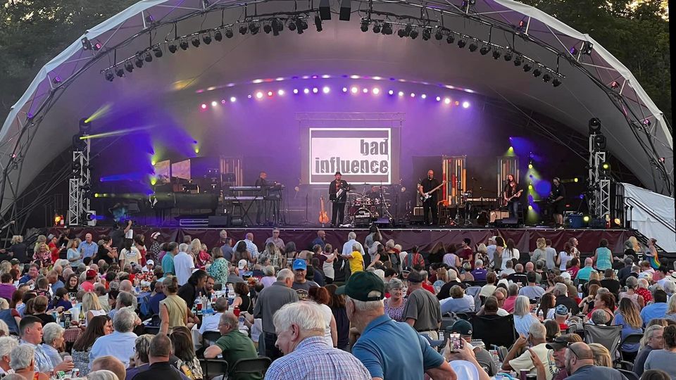 Photo of the band Bad Influence playing on a large stage in front of a crowd