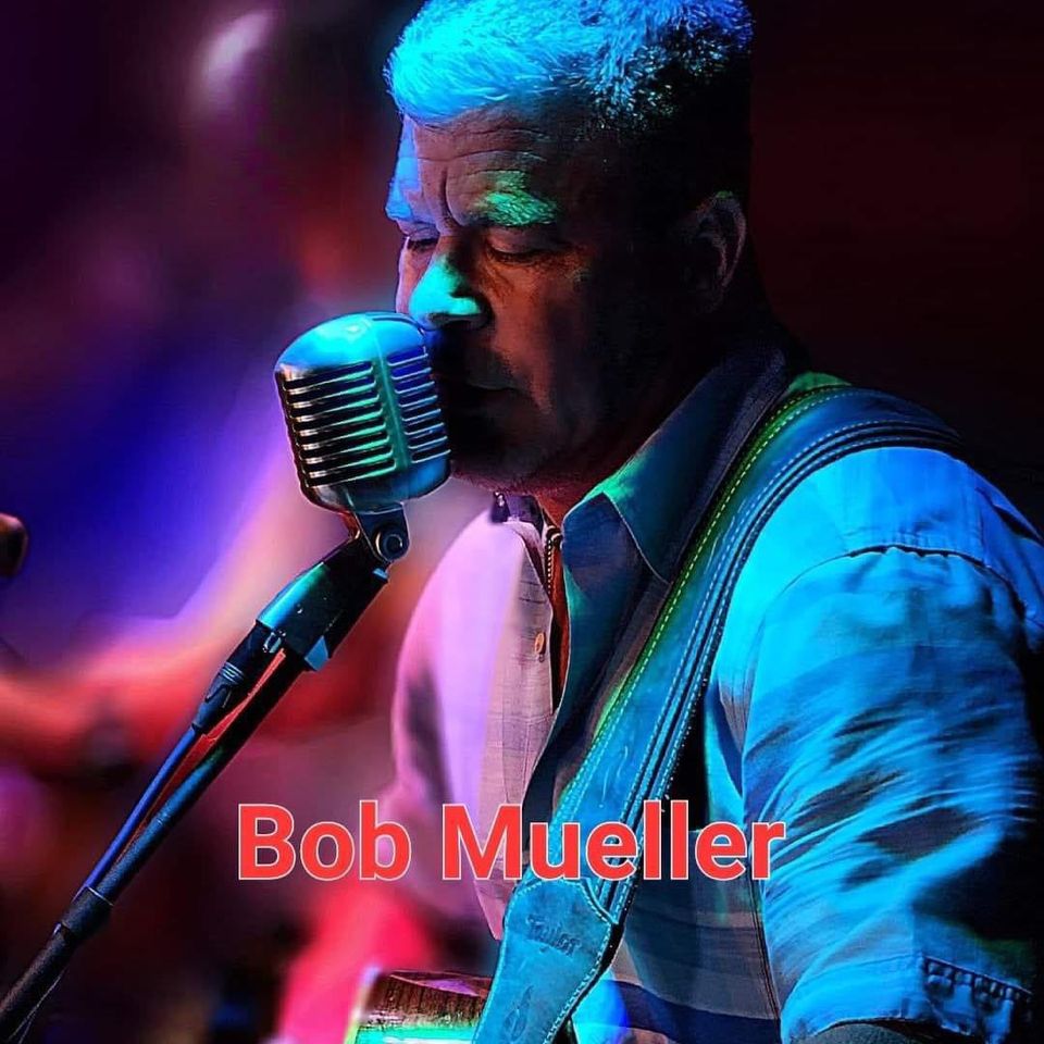 Photo of musician Bob Mueller singing into a microphone.