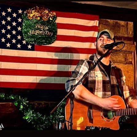 Photo of musician Blake Lang singing and playing guitar