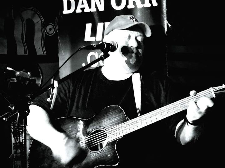 Photo of musician Dan Orr singing and playing guitar