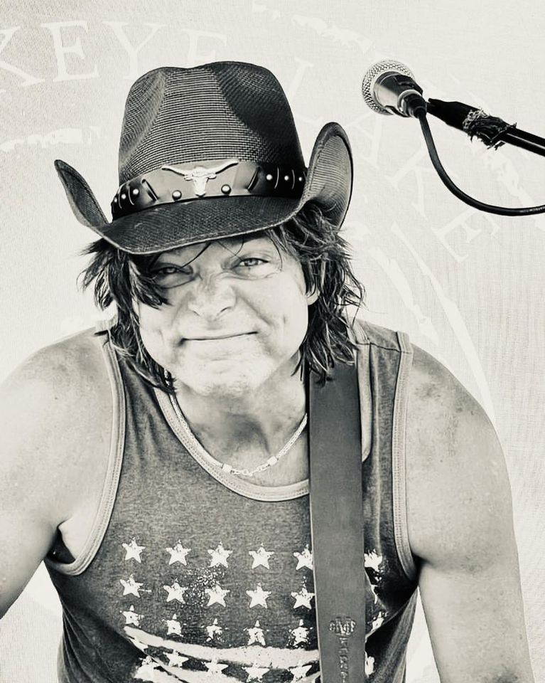 Photo of musician Brad Moore posed beside a microphone