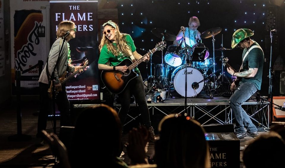 Photo of the band The Flame Keepers singing and playing instruments