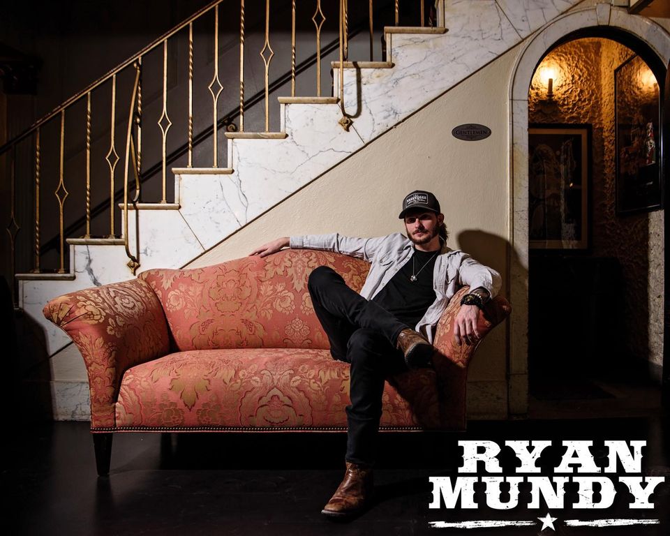 Photo of musician Ryan Mundy posing on a couch