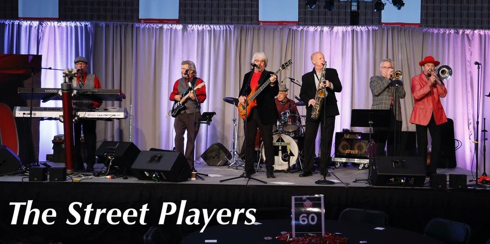 Photo of the band Street Players singing and playing instruments