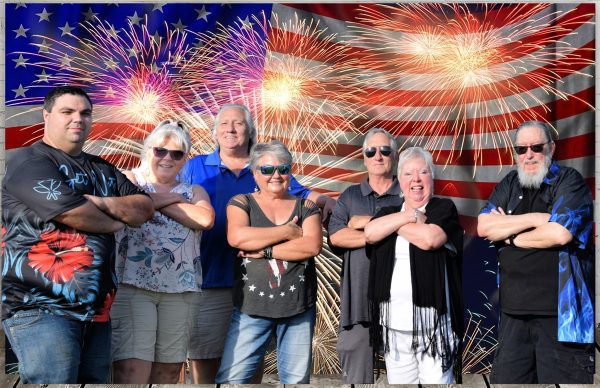 group of people standing in front of an American flag backdrop